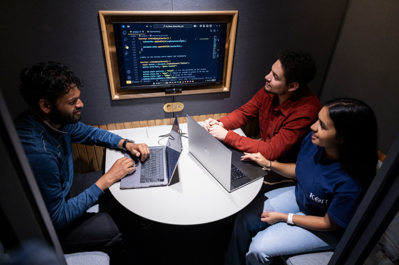 Image of students working together in a meeting booth.