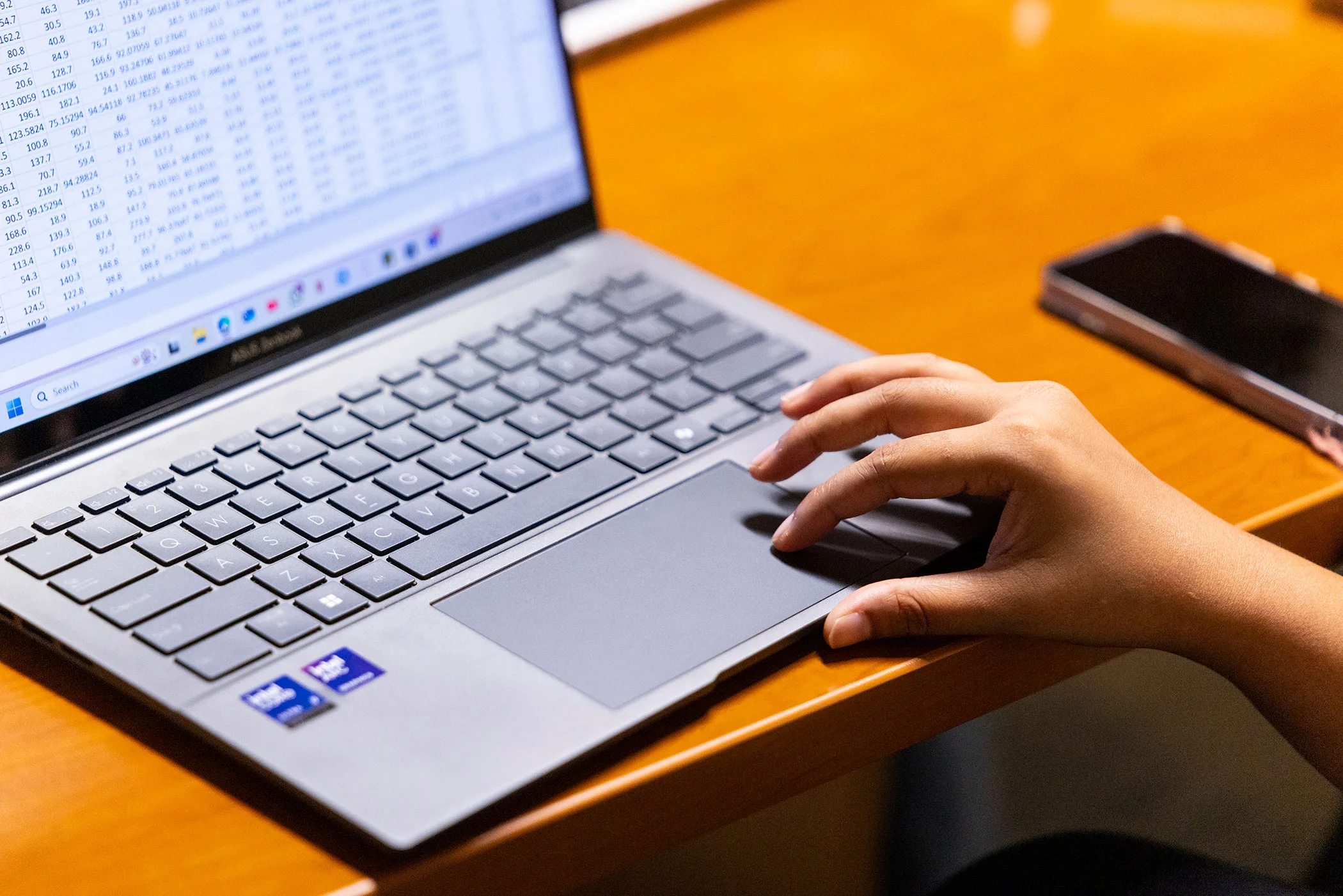A person's hand on the keyboard of a laptop computer.
